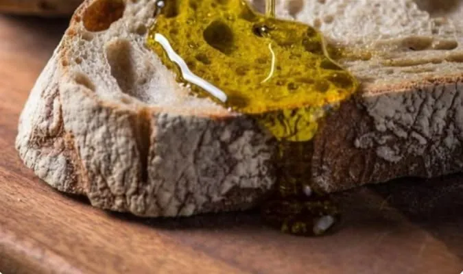 Olive oil poured over a slice of bread